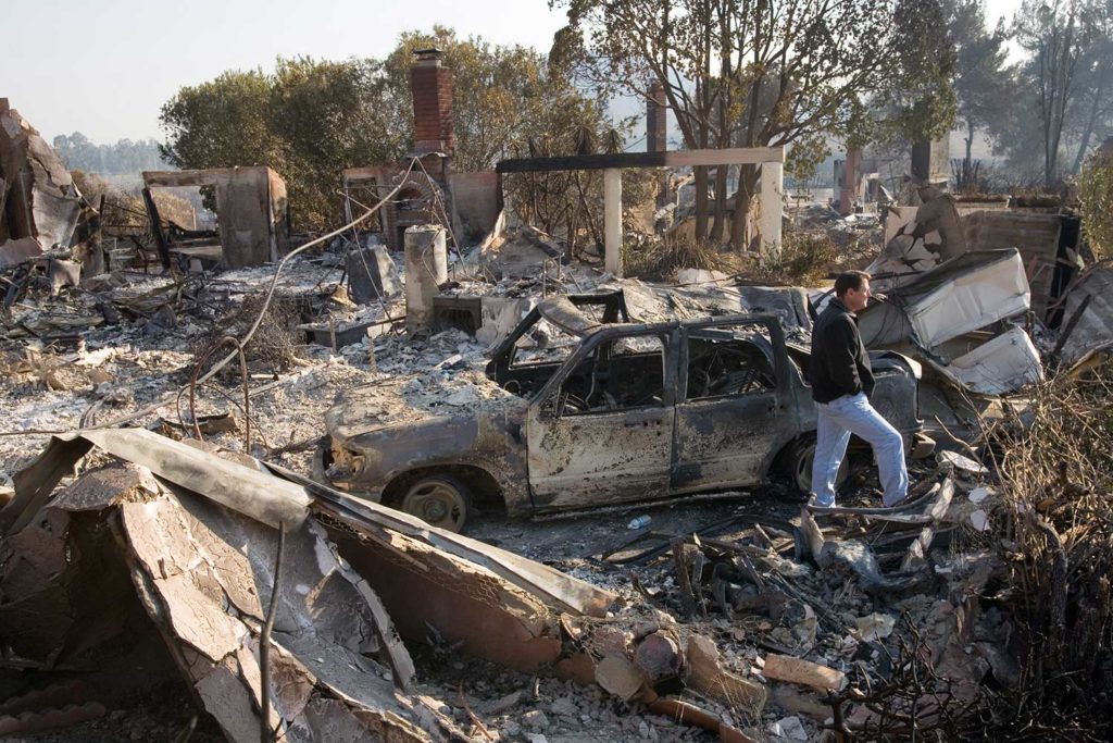 Rancho Bernardo,CA., October 26,2007--NBC reporter, Jay Gray surveys damage in Rancho Bernardo neighborhood, where wildfires destroyed much of the neighborhood. Andrea Booher/FEMA